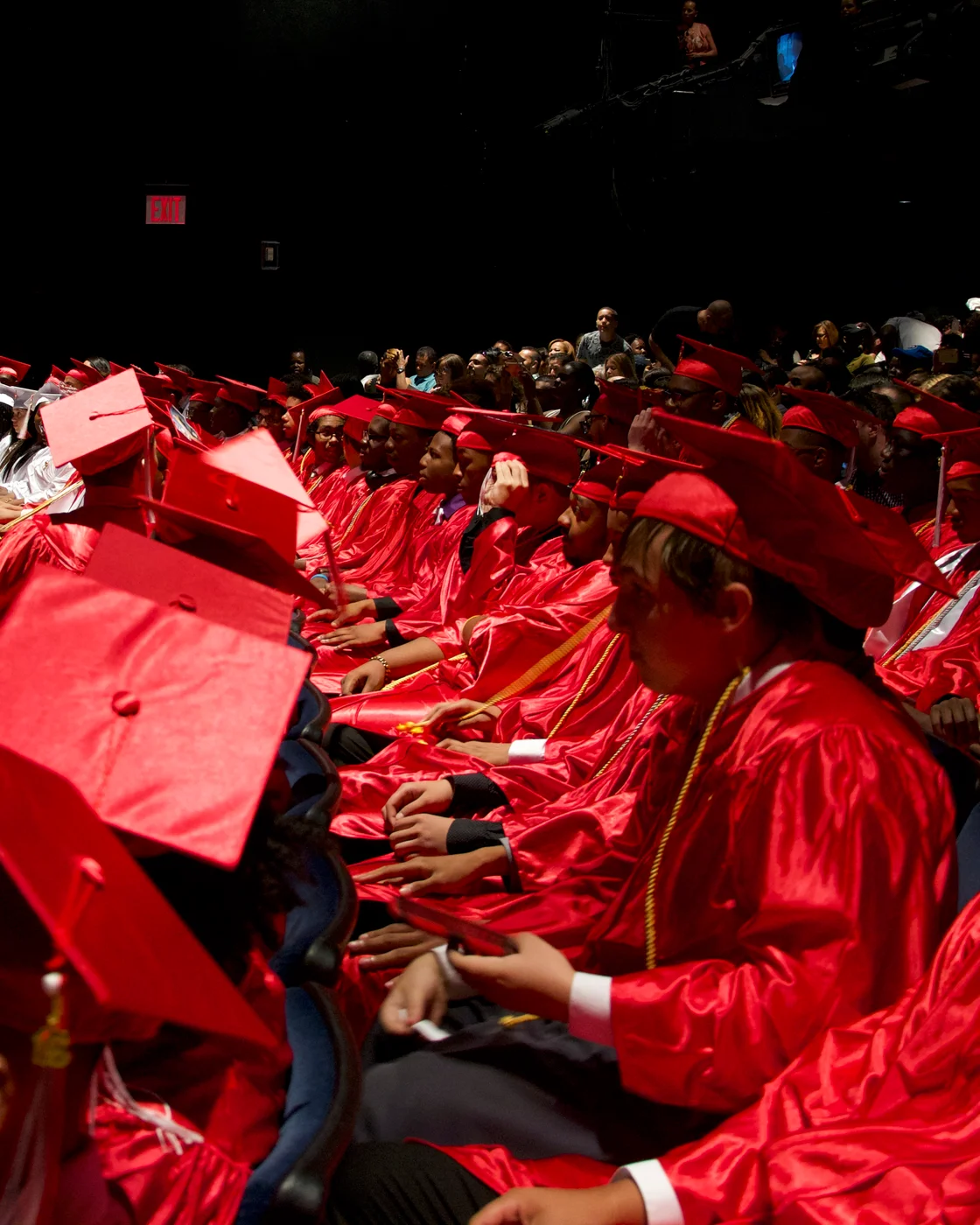 Gateway graduates in red caps and gowns at a graduation ceremony